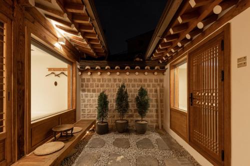 a hallway with two potted trees in a building at Luxury hanok with private bathtub - SW12 in Seoul