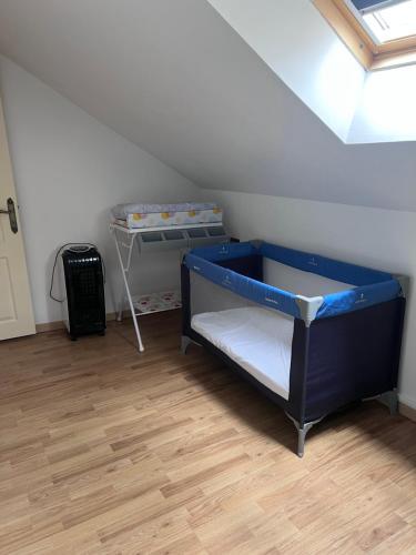 Cette chambre mansardée comprend un lit et une table. dans l'établissement Grand Appartement lumineux 2ch. Ville historique., à Verneuil-sur-Avre