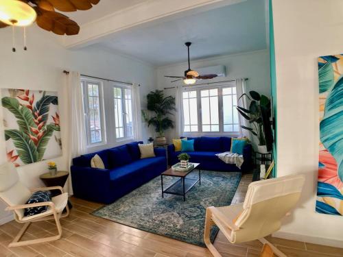 una sala de estar con sofás azules y una mesa. en Casa Blanca Miramar en San Juan