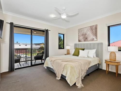 a bedroom with a bed and a balcony at Luna Sea Kingscliff with Ocean Glimpses in Kingscliff