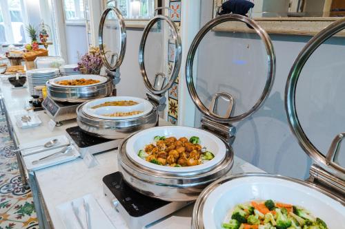 a buffet with several dishes of food on a counter at La Petite Salil Sukhumvit Thonglor 1 in Bangkok