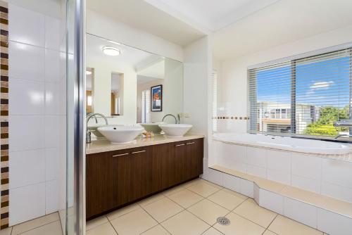 een badkamer met 2 wastafels en een groot raam bij Ocean Blue On Salt Beach in Kingscliff