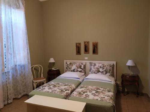 a bedroom with two beds and two tables and a window at Albergo Grande Italia in Marina di Pietrasanta