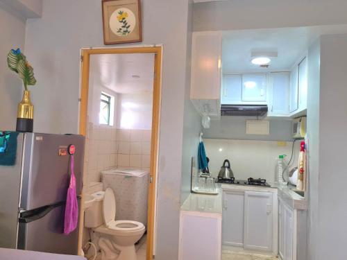 a small kitchen with a refrigerator and a toilet at Afffordable Transient Ortigas Extension in Cainta