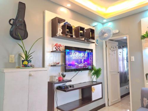 a living room with a tv on a wall at Afffordable Transient Ortigas Extension in Cainta