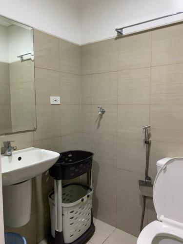 a bathroom with a sink and a toilet and a mirror at SMDC Shore Residences 1 Mall of Asia Complex Pasay in Manila