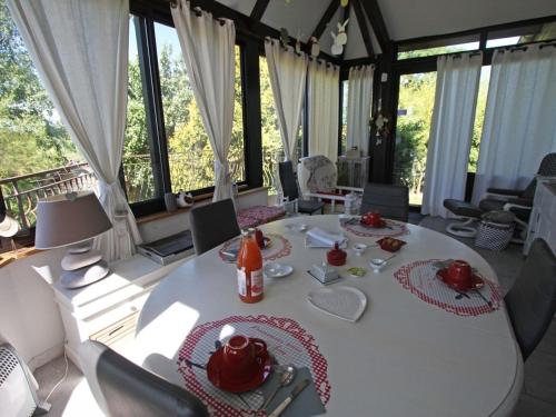 une salle à manger avec une table et des chaises blanches dans l'établissement Séjour insolite en roulotte cosy avec tout confort près d'Épinal - FR-1-589-459, à Sercoeur
