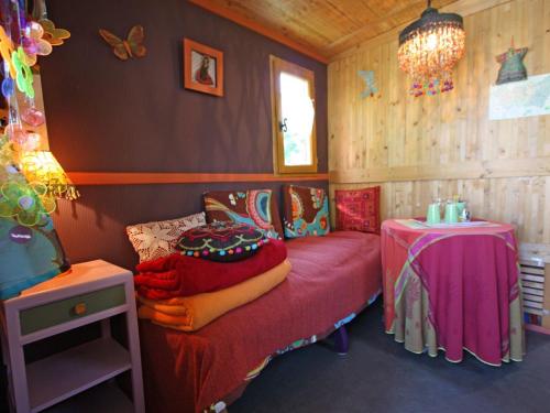 ein kleines Zimmer mit einem Bett und einem Tisch in der Unterkunft Séjour insolite en roulotte cosy avec tout confort près d'Épinal - FR-1-589-459 in Sercoeur