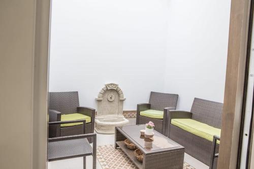 een kamer met stoelen en een tafel en een klok bij Elegante y acogedor. Buena ubicación in Osuna