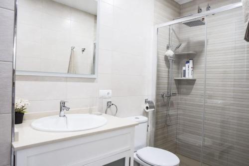 a bathroom with a sink and a toilet and a shower at Elegante y acogedor. Buena ubicación in Osuna