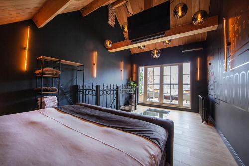 een slaapkamer met een groot bed en een tv aan de muur bij Chambers Roermond in Roermond