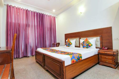 1 Schlafzimmer mit einem Bett und einem Schreibtisch sowie einem Bett der Marke sidx sidx sidx. in der Unterkunft SKS Excel Inn in Gurgaon