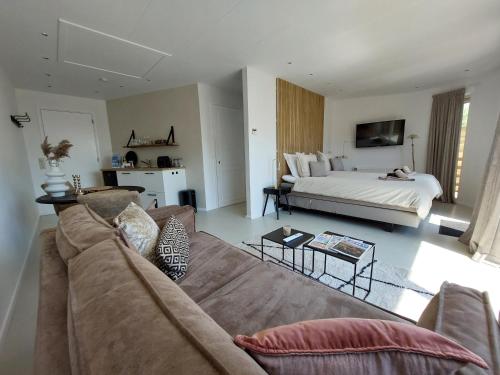 een woonkamer met een bank en een bed bij Bed & Bike Op Texel in Den Burg