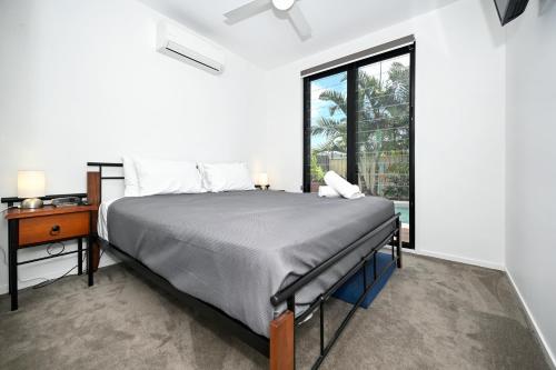 um quarto com uma cama, uma secretária e uma janela em Stylish Beach Side Gem - pool, beach ZG7 em Kawana Waters