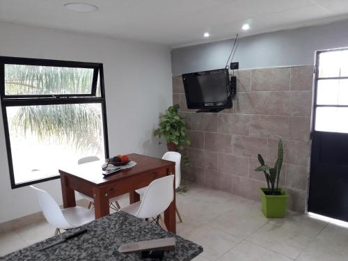 Zimmer mit einem Schreibtisch und einem TV an der Wand in der Unterkunft COSTANERA Departamento in Strobel