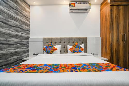 ein Schlafzimmer mit einem Bett mit einer farbenfrohen Tagesdecke in der Unterkunft FabHotel Stay Well in Indore