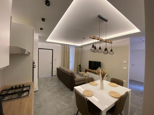 uma cozinha e sala de estar com uma mesa e um sofá em APPARTAMENTO IL MARE em Marina di Massa