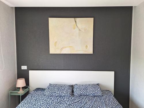 sypialnia z łóżkiem i obrazem na ścianie w obiekcie Dzintaru apartamenti w mieście Mērsrags