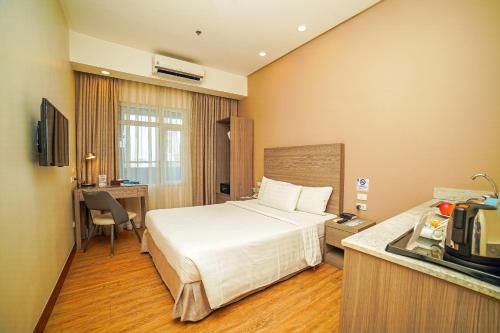 una camera d'albergo con letto e cucina di One Pacific Place Serviced Residences a Manila