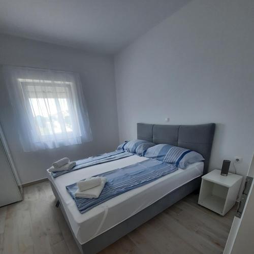 a bedroom with a large bed with a window at Apartments Matkovic in Vir