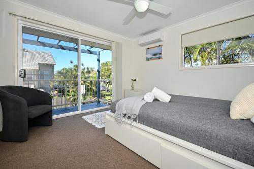a bedroom with a bed and a chair and a window at Maroochydore 3 B/R, 2 Bath, Townhouse ZA4 in Maroochydore