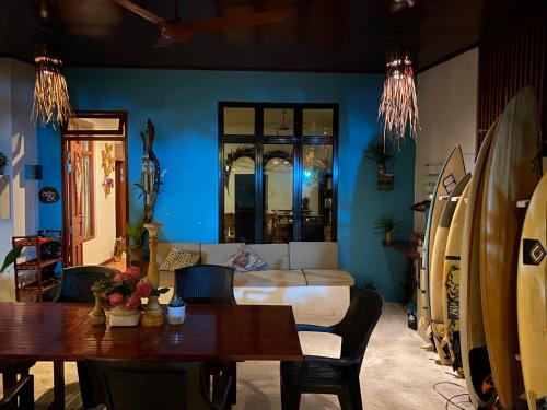 uma sala de estar com uma cama, uma mesa e pranchas de surf em Ocean Cottage Maldives em Thulusdhoo