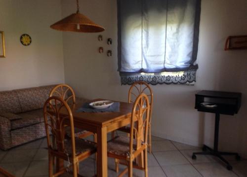 einen Tisch und Stühle in einer Küche mit Fenster in der Unterkunft Sun bay apartment in Agnone Bagni