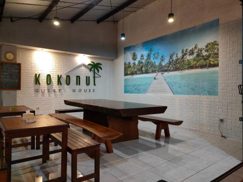 a restaurant with a table and benches in a room at Kokonut Guesthouse in Surabaya
