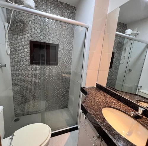 uma casa de banho com um chuveiro, um WC e um lavatório. em Flat com Churrasqueira Monte castelo em Bezerros