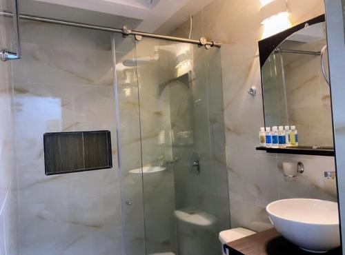 uma casa de banho com uma cabina de duche em vidro e um lavatório. em Apartamentos en el Norte de cali em Cali
