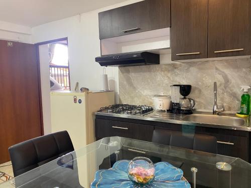 cocina con mesa de cristal y fogones en Apartamentos en el Norte de cali, en Cali