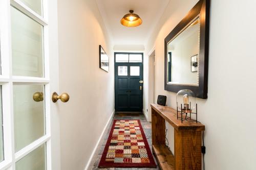 a hallway with a black door and a rug at Westhill House in Warkworth