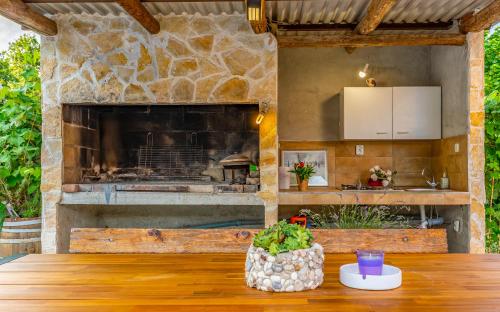 an outdoor kitchen with a large stone fireplace at Villa Iness Medulin in Medulin