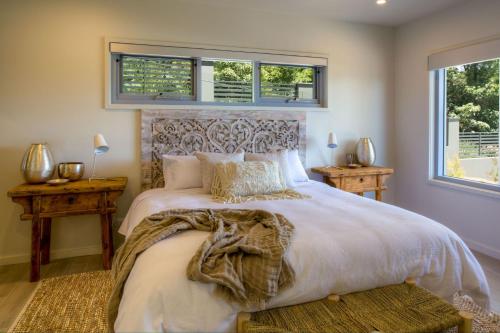 Un dormitorio con una cama grande y dos ventanas. en Lilys at Hyams, en Hyams Beach