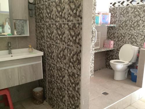 a bathroom with a toilet and a sink at Bora Red Hibiscus Lodge in Bora Bora