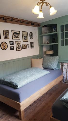 a bed in a room with pictures on the wall at Historisches Fachwerkhaus "Hoher Hirschen" mit romantischem Hof und Garten - Charmantes Studio und grosses, museales Apartment in Bodman-Ludwigshafen