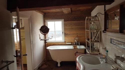 a bathroom with a tub and a sink and a window at Historisches Fachwerkhaus "Hoher Hirschen" mit eigenem Hof und Garten - Charmantes, kleineres Studio und museales Apartment in Bodman-Ludwigshafen