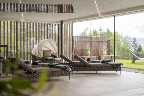 a living room with chairs and large windows at Hotel Oberwirt in Verano