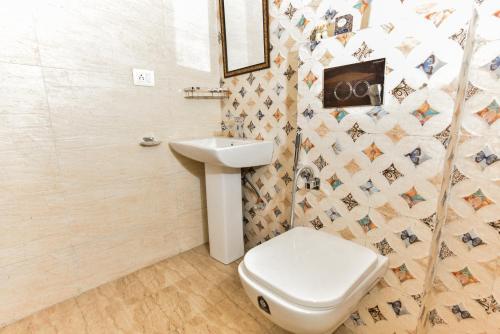 ein Bad mit einem WC und einem Waschbecken in der Unterkunft Hotel Shivaye Residency, Gurgaon 
