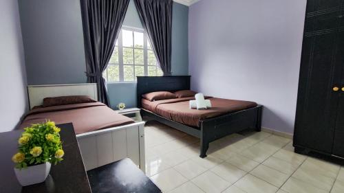 a bedroom with two beds and a window at A ONE Holiday Apartment in Tanah Rata