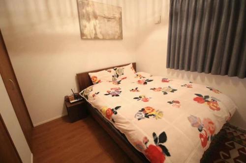 a bedroom with a bed with flowers on it at Uhome Ikebukuro Villa 7 in Tokyo