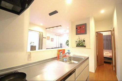 a kitchen with a sink and a large mirror at Uhome Ikebukuro Villa 7 in Tokyo