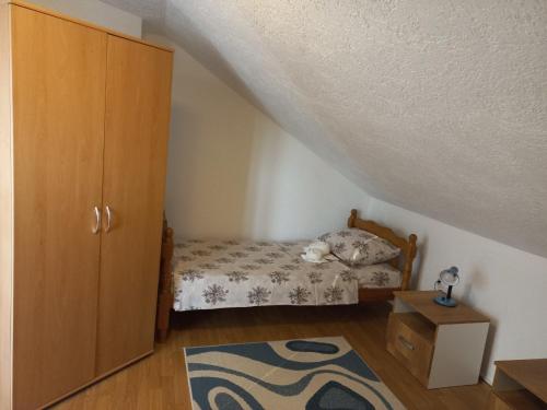 1 dormitorio con 1 cama, armario y alfombra en Apartman Saša, en Vranje