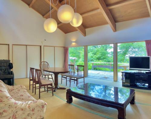 a living room with a coffee table and a tv at Kiyo's Gokokuen "Tatsumado" - Vacation STAY 06870v in Kasama