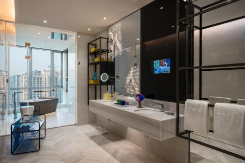 a bathroom with a sink and a large window at Renaissance Nanning Hotel in Nanning