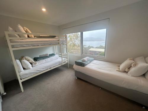 a bedroom with two bunk beds and a window at House Matterhorn in Jindabyne