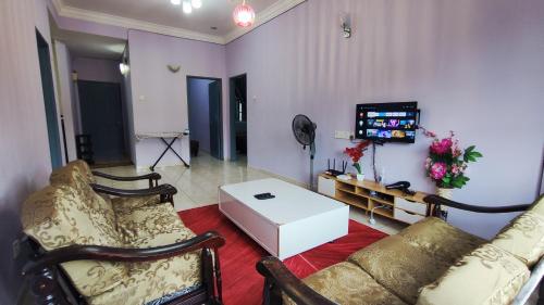 a living room with a couch and a table at A ONE Holiday Apartment in Tanah Rata