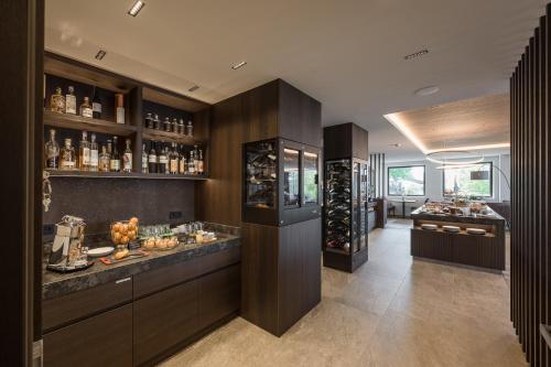 a large kitchen with a bar and a wine cellar at Hotel Oberwirt in Verano