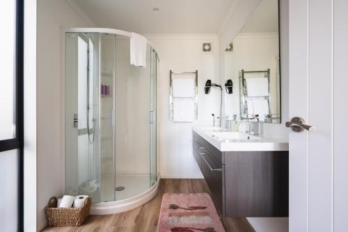 a bathroom with a shower and a sink at Modern family friendly getaway in Dunedin
