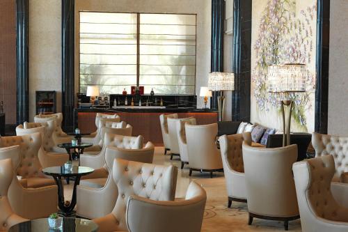 a restaurant with chairs and tables and a bar at Sheraton Shantou Hotel in Shantou